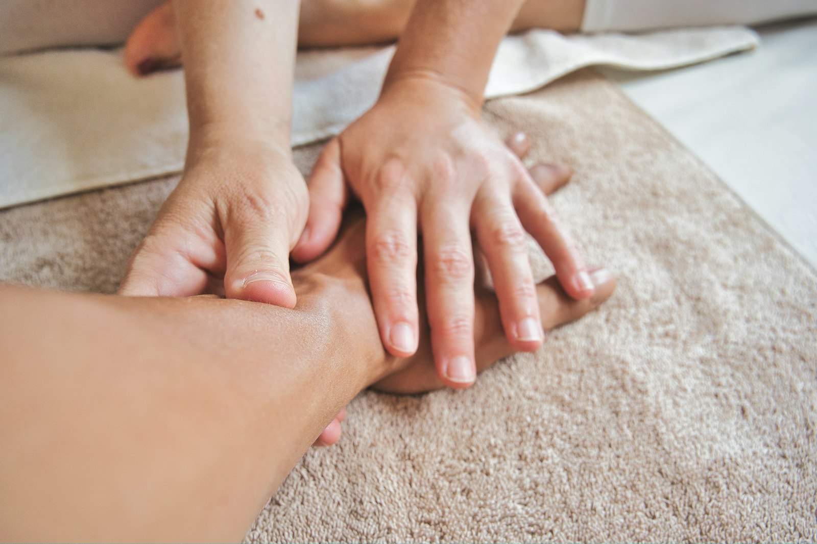 Handmassage tijdens een ontspannende behandeling op een zachte handdoek
